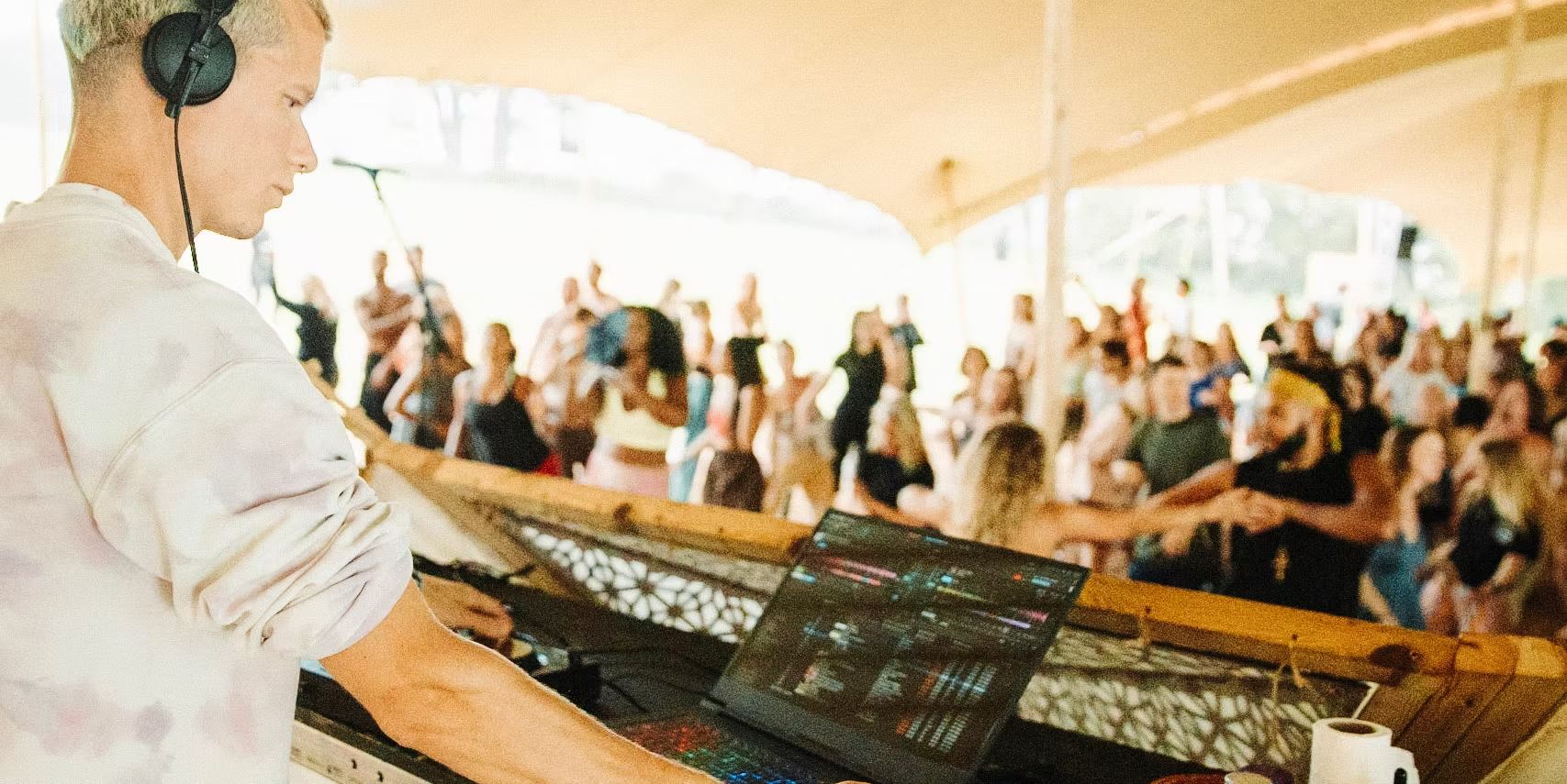 Osara DJing for a daytime ecstatic dance under a marquee